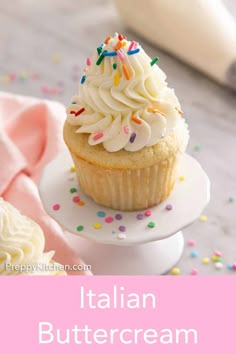 an italian buttercream cupcake with white frosting and sprinkles