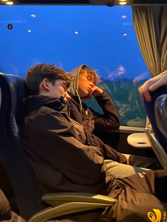 two people sitting on a train looking out the window