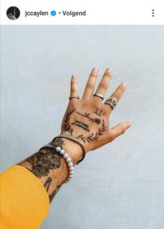 a person's hand with tattoos on it and two rings around the wrist that says i love you