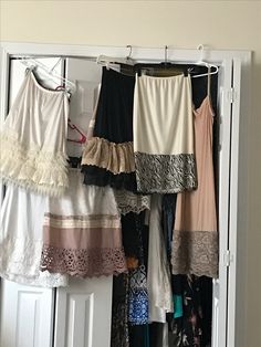 there are many different dresses hanging on the clothes rack in front of the closet door