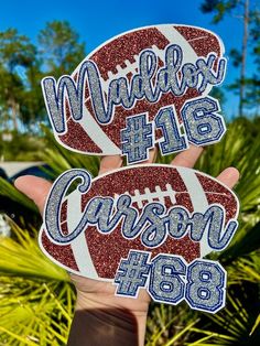 two football decals are shown in front of some palm trees and bushes, with the words madison h16 on them