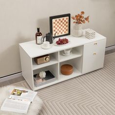 a white entertainment center with shelves and vases