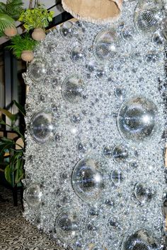 a large piece of art made out of glass balls and tinsel on the ground