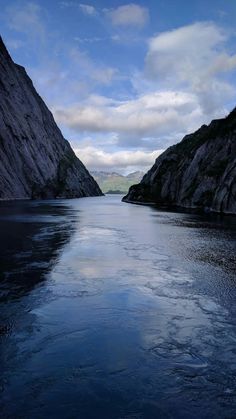 the water is crystal blue and there are mountains in the background