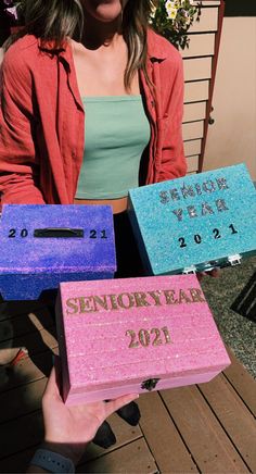 a woman holding three boxes that say happy new year and the words memory bak are written on them