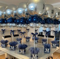 a table topped with lots of silver and blue balloons