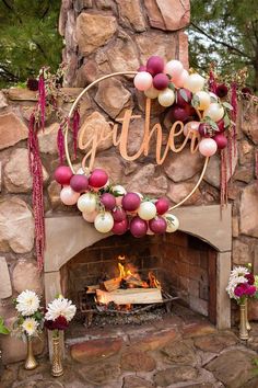 an outdoor fireplace decorated with balloons and streamers that say gather on the sign above it