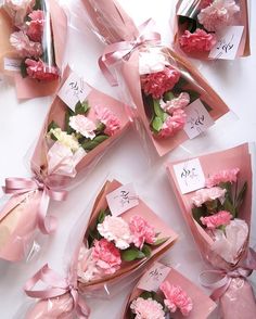 pink flowers are wrapped in cellophane and tied with ribbons on top of each other