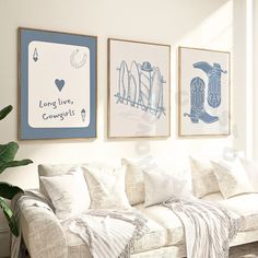 three framed pictures hang on the wall above a white couch in front of a window