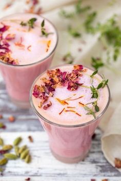 two glasses filled with pink drink and garnished with flowers