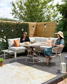 two people sitting at a table on a patio