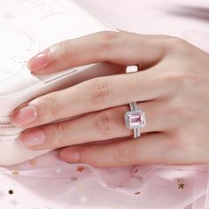 Carat Weight: 1.37 ctStone Size: 6*8 mmStone Type: Jeulia® StoneNumber of Stones: 1 Stone Color: Fancy PinkStone Shape: RadiantCarat Weight: 1.11 ctStone Size: 1.3 mmStone Type: Jeulia® StoneNumber of Stones: 60 Stone Color: Diamond WhiteStone Shape: RoundWeight: 5.42 gWidth: 11.3 mmHeight: 8.8 mmThickness: 2.5 mmMaterial: 925 SilverPlating Color: Silver Moissanite Bridal Set With Halo Setting, Moissanite Bridal Sets With Halo Setting For Promise Ring, Pink Moissanite Diamond Ring As Gift, Emerald Cut Halo Diamond Promise Ring, Pink Moissanite Diamond Ring For Anniversary, Pink Cubic Zirconia Halo Ring For Wedding, Pink Diamond Ring With Emerald Cut And Halo Setting, Pink Emerald-cut Diamond Ring With Halo Setting, Pink Emerald Cut Diamond Ring With Halo Setting