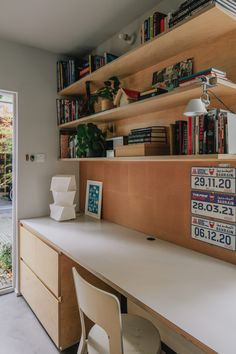 a room with a desk, bookshelf and sliding glass door