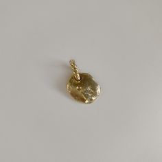 a small gold pendant with a rope on it