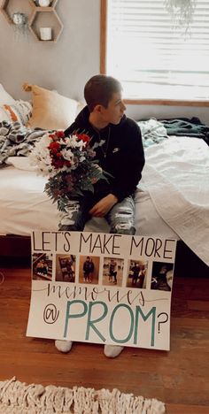 a young boy sitting on top of a bed next to a sign that says let's make more friends prom