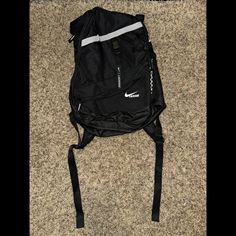 a black nike backpack laying on the floor