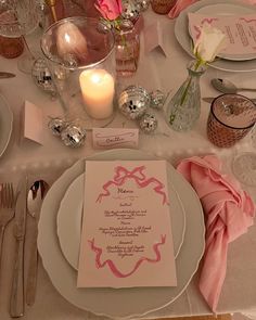 the table is set with silverware and pink napkins