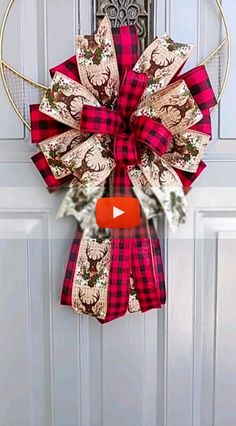 a red and black plaid christmas wreath hanging on a door with the word merry written below it