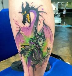 a man with a tattoo on his leg has an image of a dragon and a demon