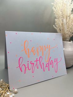 a happy birthday card sitting on top of a table next to a potted plant