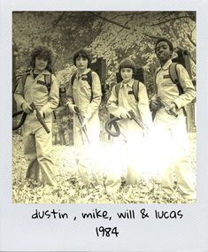 an old black and white photo of four people with backpacks on, standing next to each other