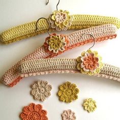 crocheted hair clips with flowers on them sitting next to each other in different colors