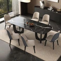 a dining room table with chairs and a rug on the floor in front of it