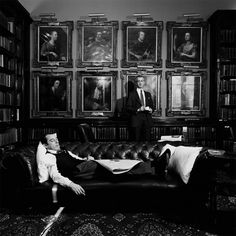 a man laying on top of a couch in a room filled with bookshelves