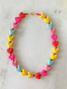 "Kids Brite Multi Colored Plastic Heart Necklace with Red Mini Spacer Beads Gold Tone Spring Ring Clasp Closure Brite Multi Hearts are Red, Hot Pink, Pink, Aqua, Yellow Hearts Measure 5/8\" Wide Necklace Measures 15\" Imported COMPLIMENTARY DOMESTIC SHIPPING" Red Beaded Necklace For Valentine's Day Gift, Red Round Beaded Necklaces For Valentine's Day, Red Round Beads Necklace For Valentine's Day, Playful Heart Beads For Jewelry Making, Cute Multicolor Jewelry With Heart Beads, Valentine's Day Red Beaded Necklaces, Cute Multicolor Heart Beads Jewelry, Valentine's Day Heart Charm Necklace With Round Beads, Valentine's Day Necklace With Heart Charm And Round Beads