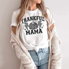 a woman wearing a white t - shirt with the words,'thank mama'on it