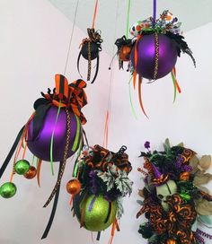 three halloween decorations hanging from the ceiling and decorated with orange, green, and purple ribbons