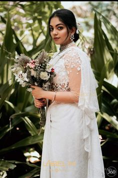 a woman in a white dress holding flowers