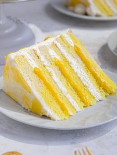 a slice of yellow cake sitting on top of a white plate next to other plates