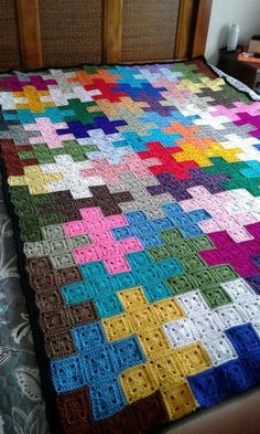 a crocheted blanket on top of a bed