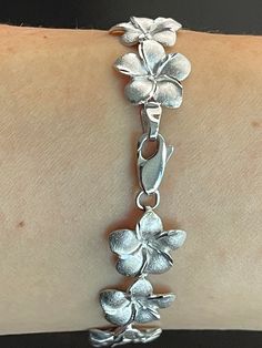 Elegant And Beautiful Hawaiian 14mm Plumeria Flower Lei Bracelet 7 1/4" in 14K Solid White Gold  Diamond Cut on the edges of each petal. 14 Karat Solid White Gold GUARANTEED, Authenticated with a 14K Stamp Made With the Highest Quality Craftsmanship Solid 14K White Gold Plumeria Flower Lei Link Bracelet  Length 7.25 Inches Solid 14K White Gold Plumeria Flower Width 14 Millimeters Total Weight 15.8 grams Amazing! Gift For Family And Friends! A Bracelet Jewelry Gift Box Included! Silver Flower Jewelry, Cute Silver Jewelry, Silver Flower Bracelet, Flower Lei, Plumeria Flowers, Jewelry Accessories Ideas, Dope Jewelry, Funky Jewelry, Jewelry Lookbook