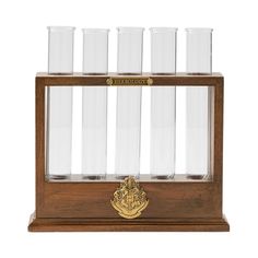 a wooden case with six glasses on it and a gold emblem in the middle,