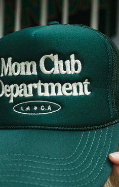 Mom Club Department " LA*CA " hunter green trucker hat. Classic trucker hat with a 90s vibe at the front panel. Airy mesh at the back complete with an adjustable snapback. Features- Slyfox Threads Mom Club Department " LA*CA "- Paneled trucker hat with an adjustable snapback Content + Care 5 panel cap Size: OSFM - Adult (58cm/22.8") Spot clean 100% Polyester Structured Firm Front Panel Seamless Foam Front Panel with Lining Slight Curved Visor 6 Rows Stitching on Visor Matching Fabric Undervisor Retro Trucker Hat With Curved Bill For Streetwear, Retro Curved Bill Trucker Hat For Streetwear, Adjustable Green Mesh Baseball Cap, Green Adjustable Mesh Baseball Cap, Adjustable Green Mesh Snapback Hat, Green Adjustable Mesh Snapback Hat, Green Mesh Trucker Hat Baseball Cap, Green Mesh Trucker Snapback Hat, Green Mesh Trucker Hat