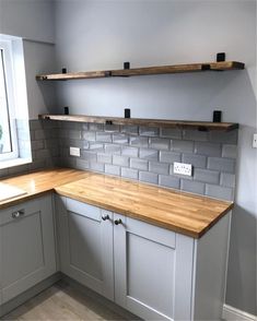 a kitchen with gray cabinets and wooden counter tops