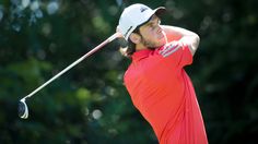 a man swinging a golf club at a ball