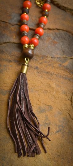 Orange jade, Tibetan agate, coconut shell, wood and gold chain with re-purposed, dark brown, signature, bullet shell leather tassel. Bohemian style necklace is approximately 33" in length. Every item sold plants a tree through our partnership with One Tree Planted. Wood And Gold, Bullet Shell, Pave Necklace, Horn Necklace, Horn Pendant, Pave Pendant, African Turquoise, Natural Coral, Trendy Necklaces