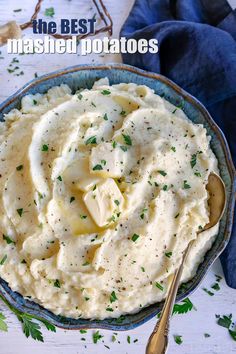 mashed potatoes in a blue bowl with a spoon on the side and parsley sprinkled over top