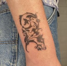 a woman's arm with a tattoo design on the left side of her arm