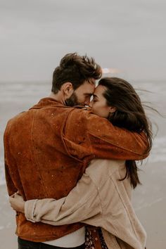 a man and woman embracing on the beach