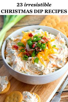 a white bowl filled with dip and crackers on top of a wooden cutting board