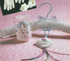 a crocheted bag, mitts and gloves on a pink tablecloth with white flowers