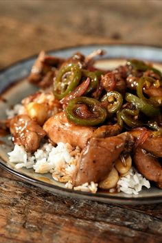 a plate with rice, meat and peppers on it