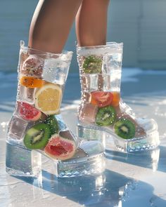 a woman's legs wearing clear boots with fruit slices and kiwis on them