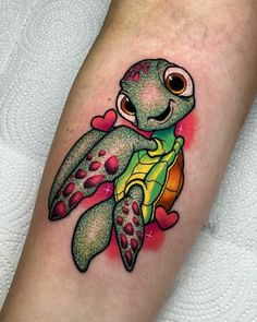 a turtle tattoo on the arm with hearts around it's eyes and an eyeball