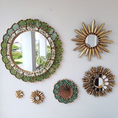 there are four mirrors on the wall and one is gold, blue, and green