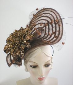 An elegant ladies women's fascinator hat for Kentucky Derby, church, ladies luncheon or tea, Easter, or any event. This would look so pretty with a cream, tan, brown or light pink dress or suit. A sheer brown straw disc is hand manipulated and sculpted into a dramatic shape then topped with two striped quills from England. An oversize "giraffe" print flower and dotted vintage netting seals the deal. Mounted to a silk-covered straw base with narrow headband and comb to help keep it in place. One Fitted Brown Hat For Kentucky Derby, Brown Brimmed Evening Hat, Evening Brown Brimmed Hat, Elegant Beige Headpieces For Spring, Formal Brown Hat, Elegant Brown Hats For Formal Occasions, Fitted Beige Headpiece For Races, Elegant Beige Headpiece For Formal Occasions, Elegant Brown Formal Hats